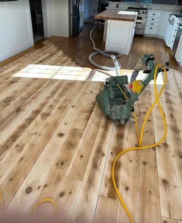 Wide-plank floor sanded back to raw wood mid-refinish